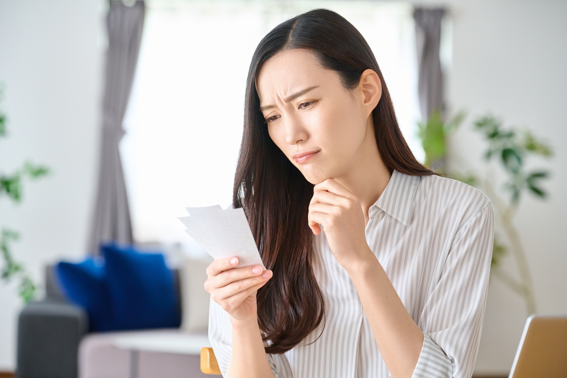 レシートを見て家計に悩む女性